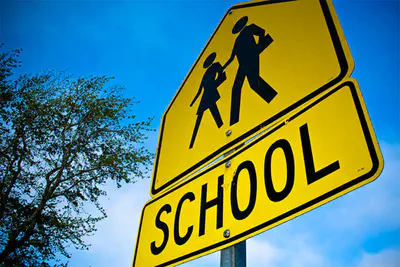 photo of a traffic sign that says SCHOOL